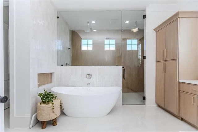 a bathroom with a bathtub a mirror a double vanity sinks and vanity