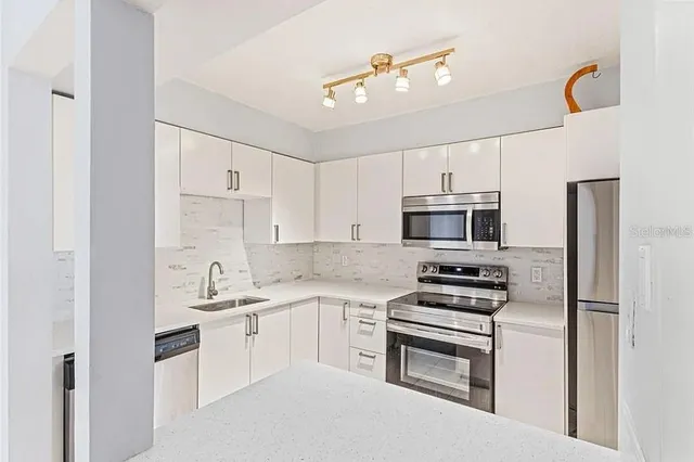 a kitchen with cabinets stainless steel appliances and a counter top space