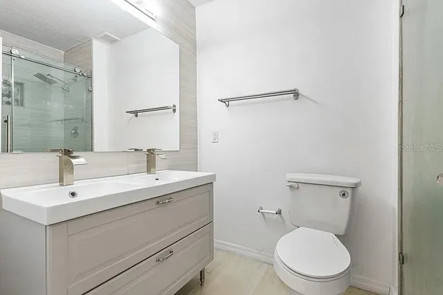 a bathroom with a toilet a sink and mirror
