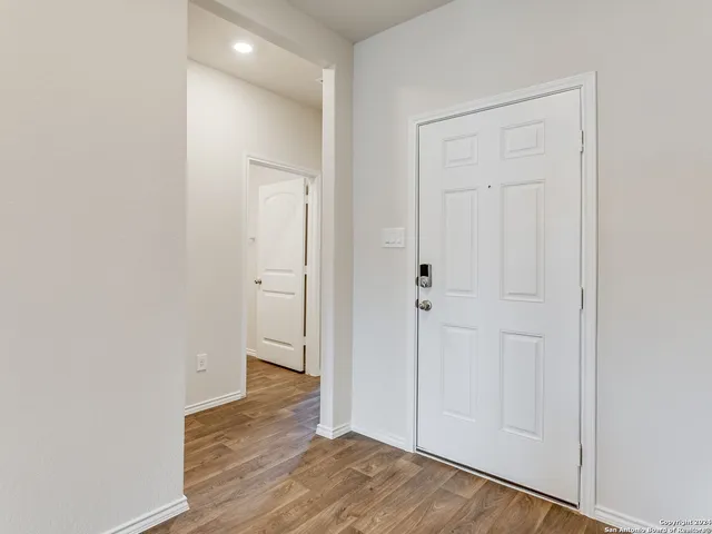 an empty room with wooden floor & closet area