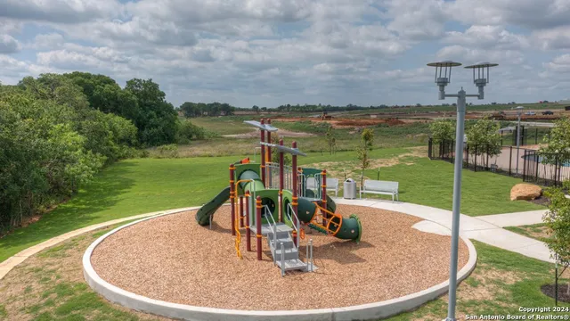 a view of a swimming pool with a bench and lawn chairs