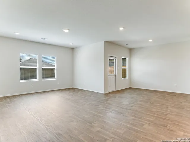 a view of a big room with wooden floor and windows