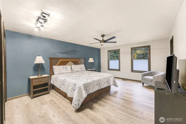 a bedroom with a bed wooden floor and window