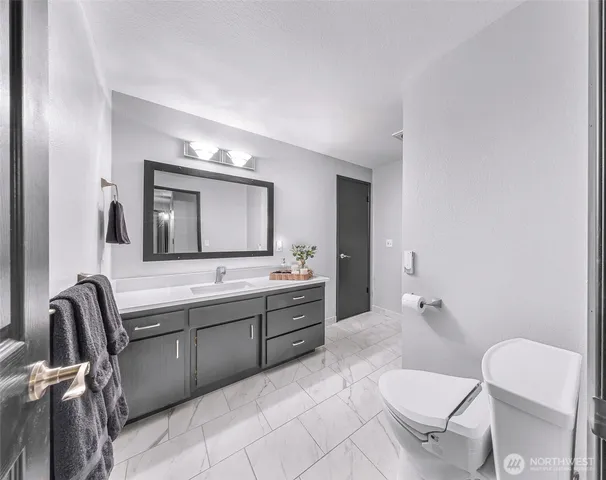 a bathroom with a toilet a sink and mirror