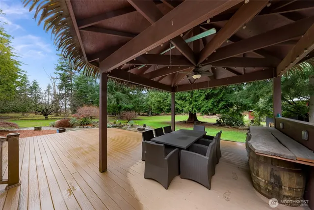a view of a patio with table and chairs potted plants with wooden floor and fence