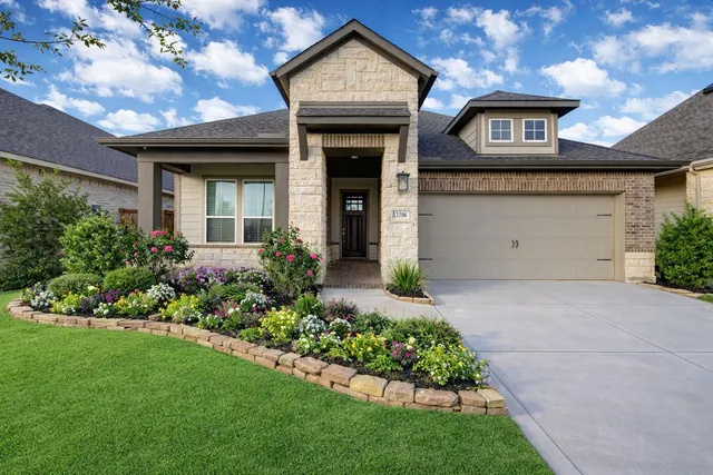 a front view of a house with a garden and plants