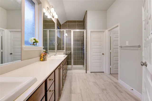 a bathroom with a sink a mirror and shower