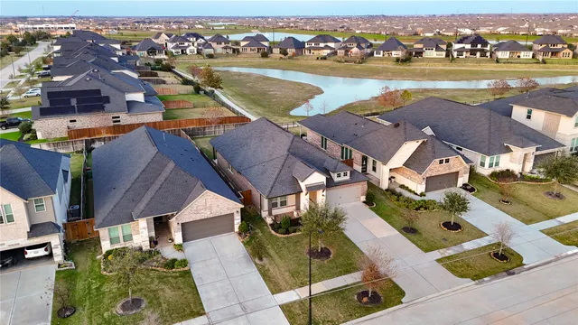 an aerial view of residential houses with outdoor space and ocean view