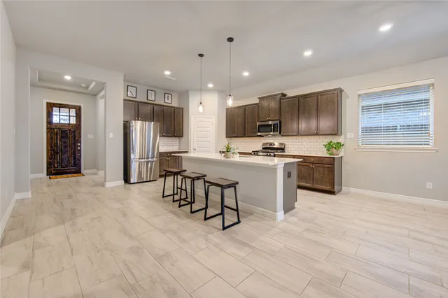 a kitchen with stainless steel appliances a refrigerator and a stove top oven