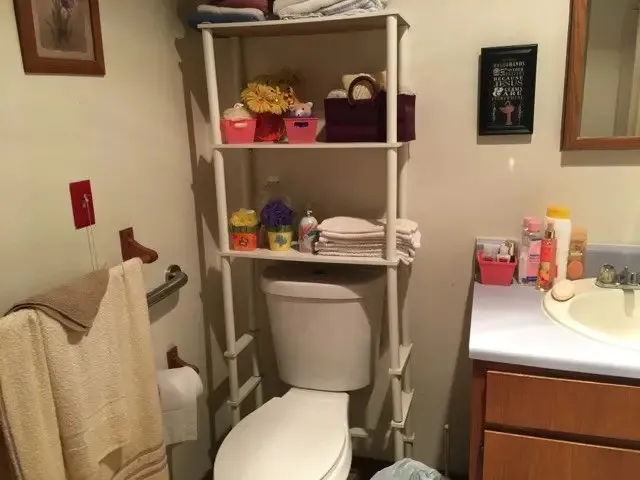 a bathroom with a toilet sink vanity and mirror