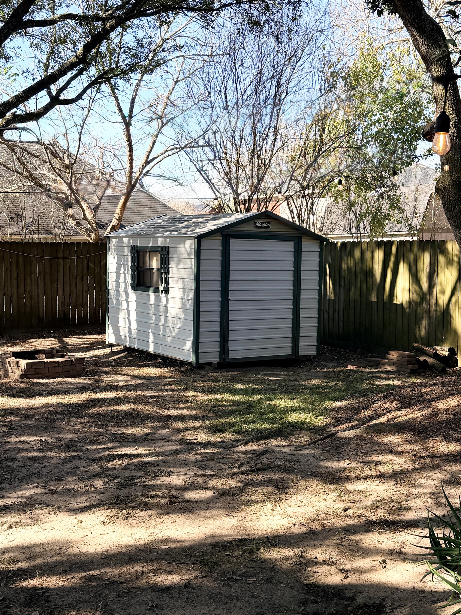 245 North Ranch House Road Angleton, TX 77515 - Photo 16 of 19 Charming backyard shed surrounded by mature trees—ideal for extra storage or a little workshop space.