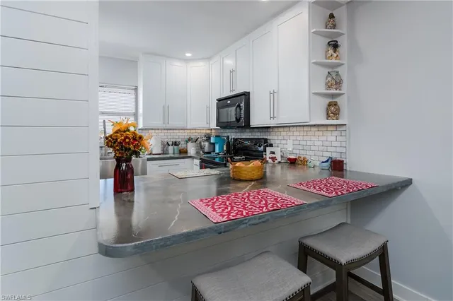 a kitchen with a stove a faucet and cabinetry