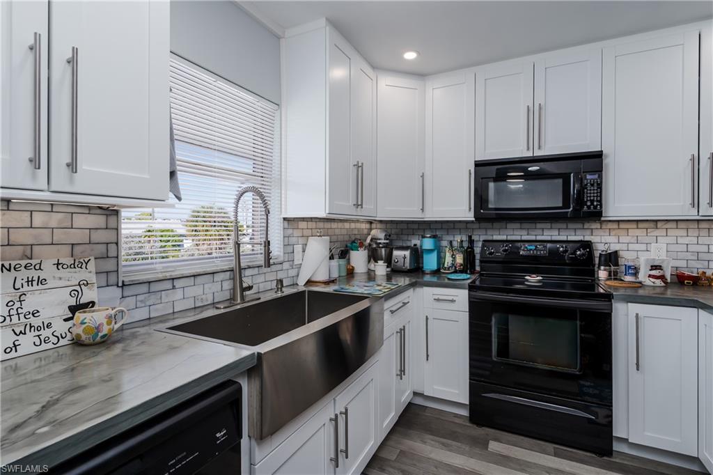 5499 Rattlesnake Hamm Road, Unit 304A Naples, FL 34113 - Photo 14 of 30 a kitchen with granite countertop a stove sink and microwave
