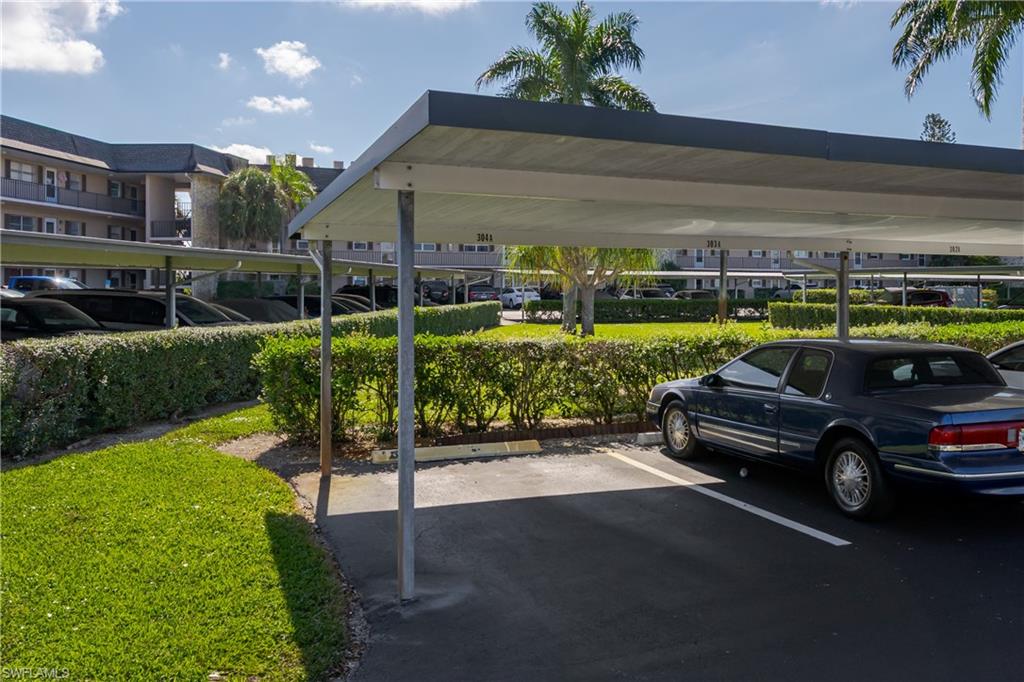 5499 Rattlesnake Hamm Road, Unit 304A Naples, FL 34113 - Photo 20 of 30 a car parked in the yard and a car parked