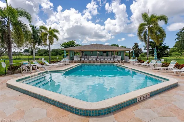 a view of a swimming pool with a lounge chairs in the patio