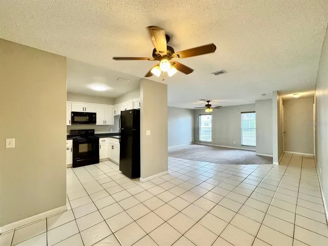 a view of a kitchen with a sink and a refrigerator