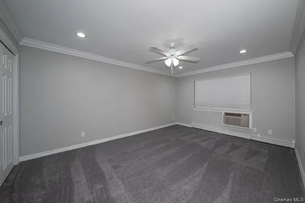 an empty room with a white walls and chandelier fan