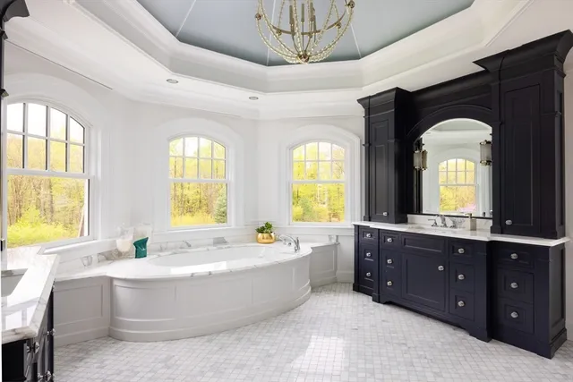 a spacious bathroom with a tub double sink window and mirror