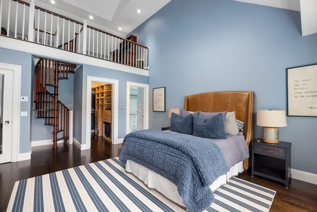 a bedroom with a bed stairs and a large window
