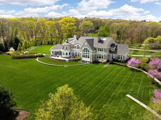 a front view of a house with a big yard and potted plants