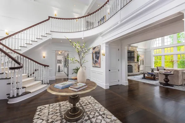a living room with couches and a dining table with wooden floor