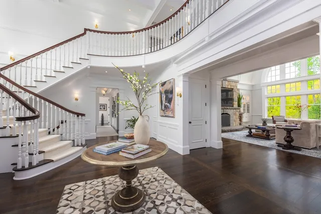 a living room with couches and a dining table with wooden floor