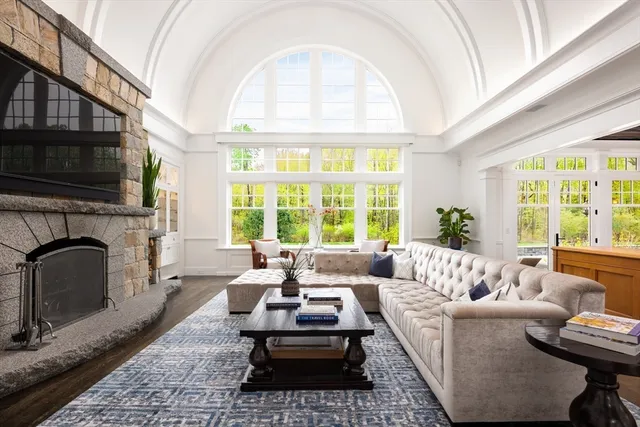 a living room with furniture a large window and a fireplace