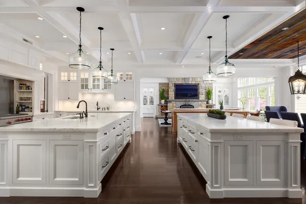 a large white kitchen with lots of counter space sink and appliances