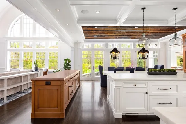 a large kitchen with kitchen island a large window a sink and appliances