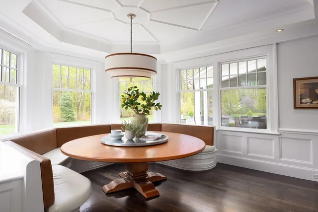 a dining room with wooden floor and a chandelier