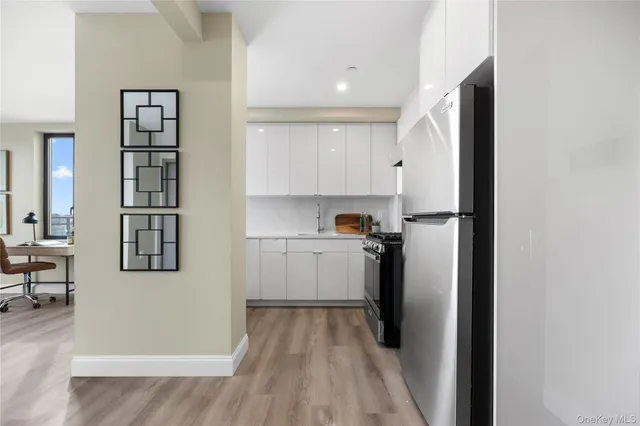a view of a kitchen with refrigerator and wooden floor