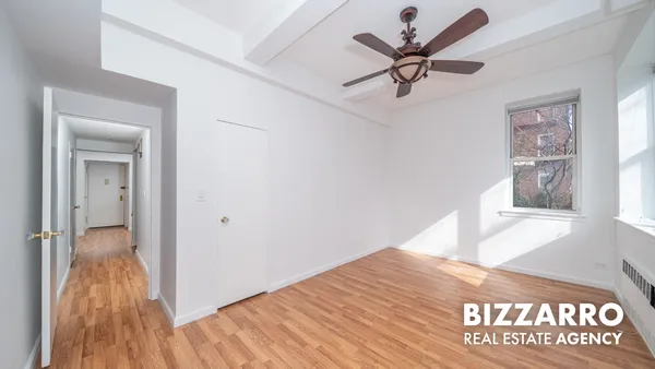 a view of empty room with wooden floor