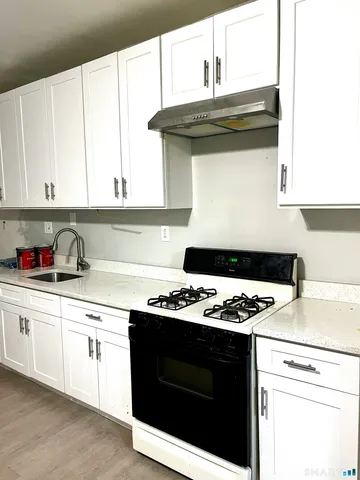 a kitchen with a stove and white cabinets