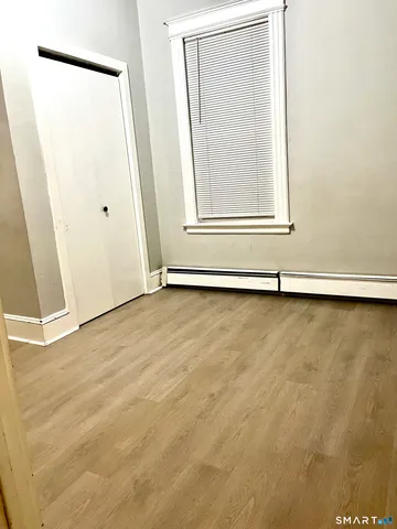 a view of a small space with wooden floor and a window