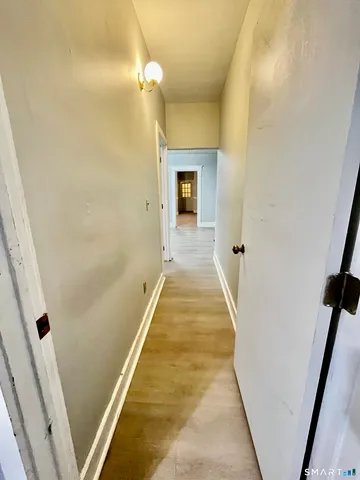 a view of a hallway with wooden floor and staircase