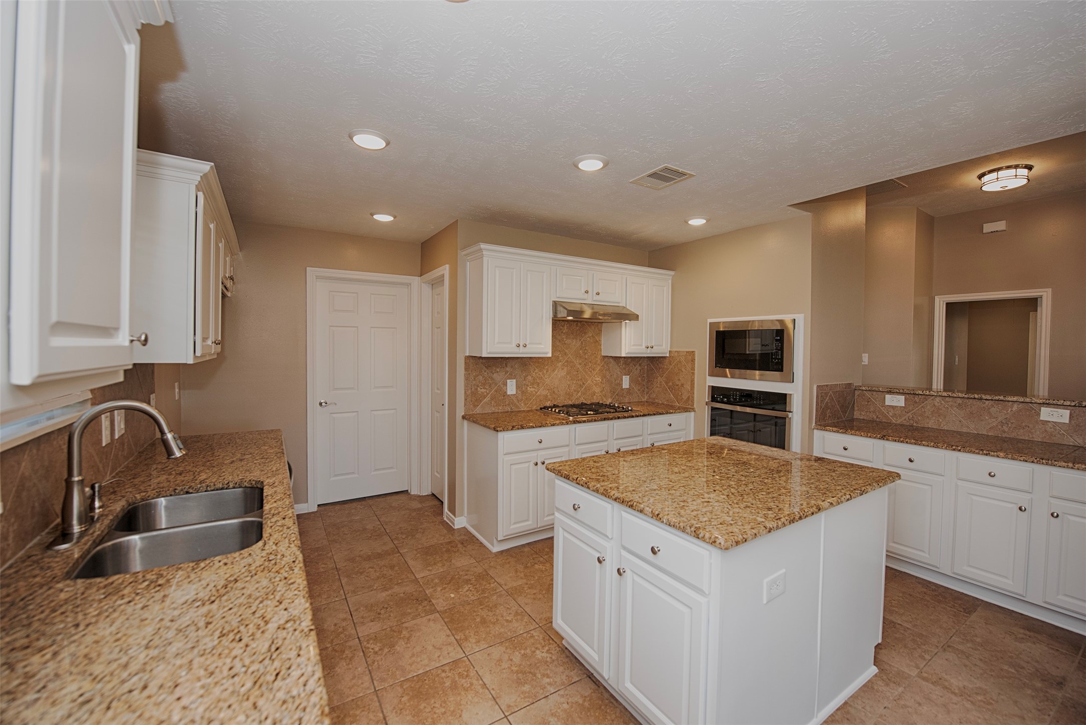 6714 Lone Star Ridge Manvel, TX 77578 - Photo 15 of 37 a kitchen with stainless steel appliances granite countertop a sink stove and refrigerator