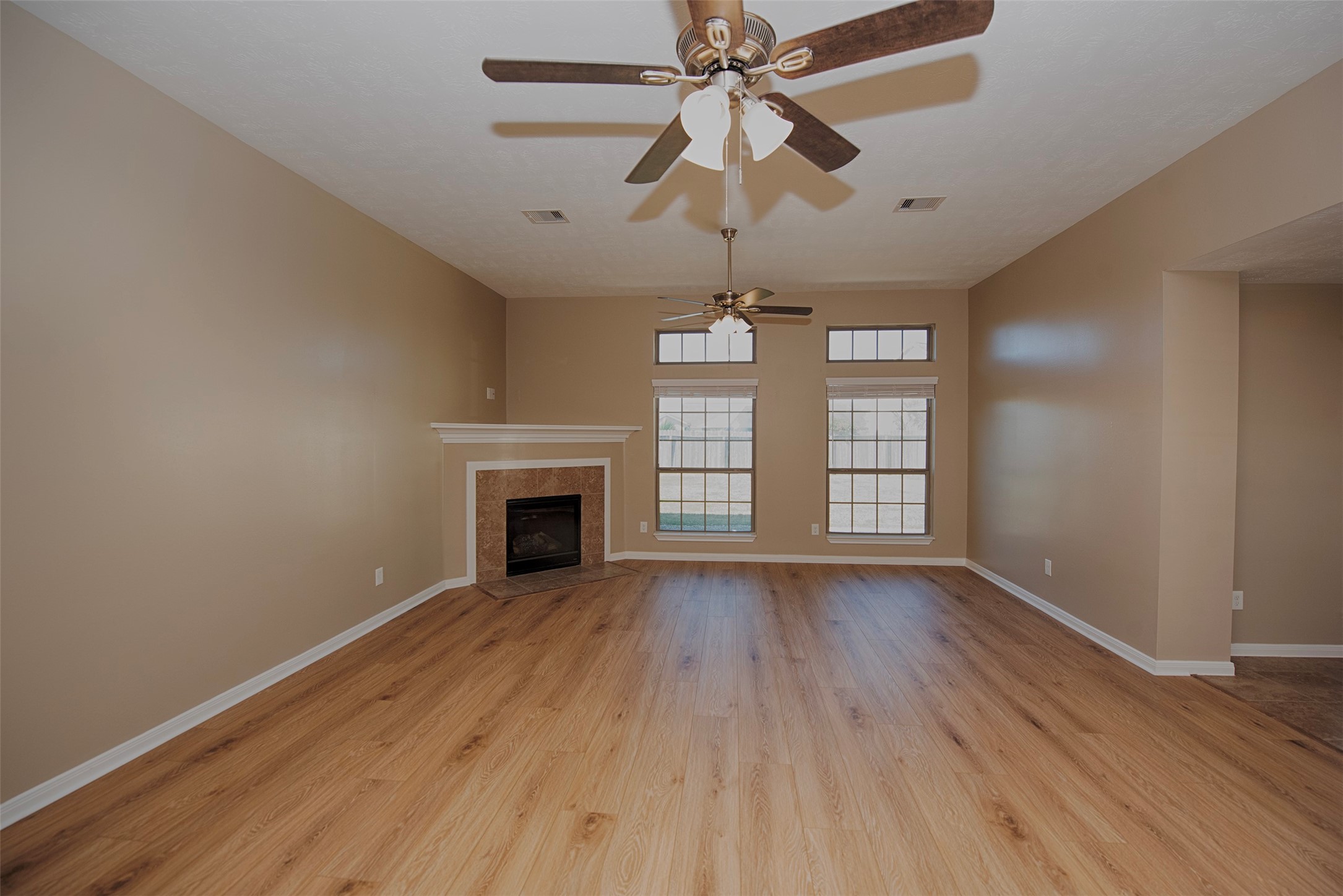 6714 Lone Star Ridge Manvel, TX 77578 - Photo 7 of 37 an empty room with wooden floor chandelier fan and windows
