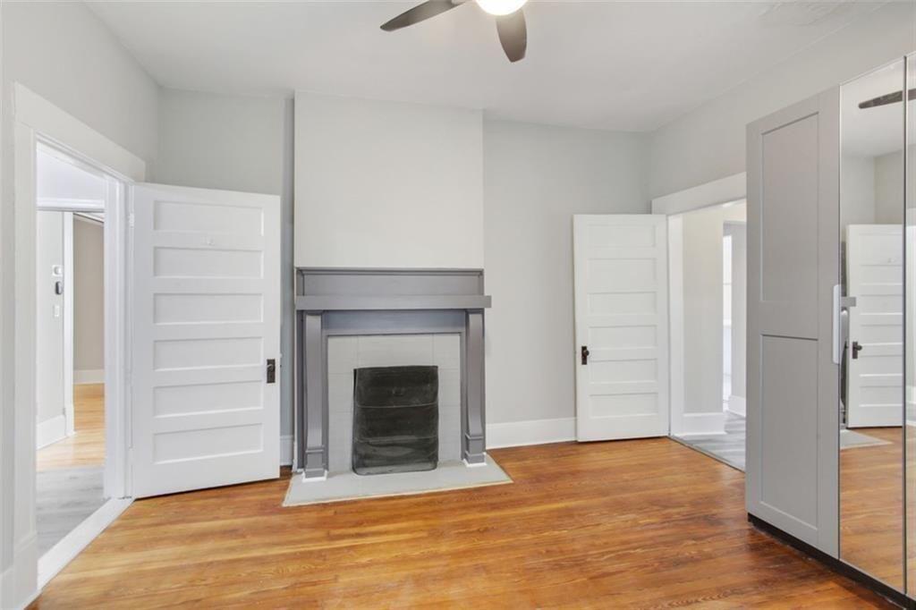 693 Myrtle Street Northeast Atlanta, GA 30308 - Photo 13 of 35 a view of an empty room with wooden floor fireplace and a window