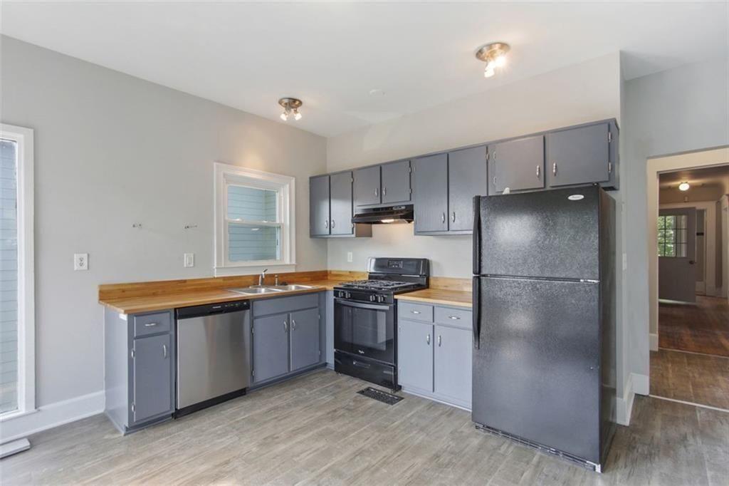 693 Myrtle Street Northeast Atlanta, GA 30308 - Photo 19 of 35 a kitchen with stainless steel appliances granite countertop a refrigerator a stove and a sink