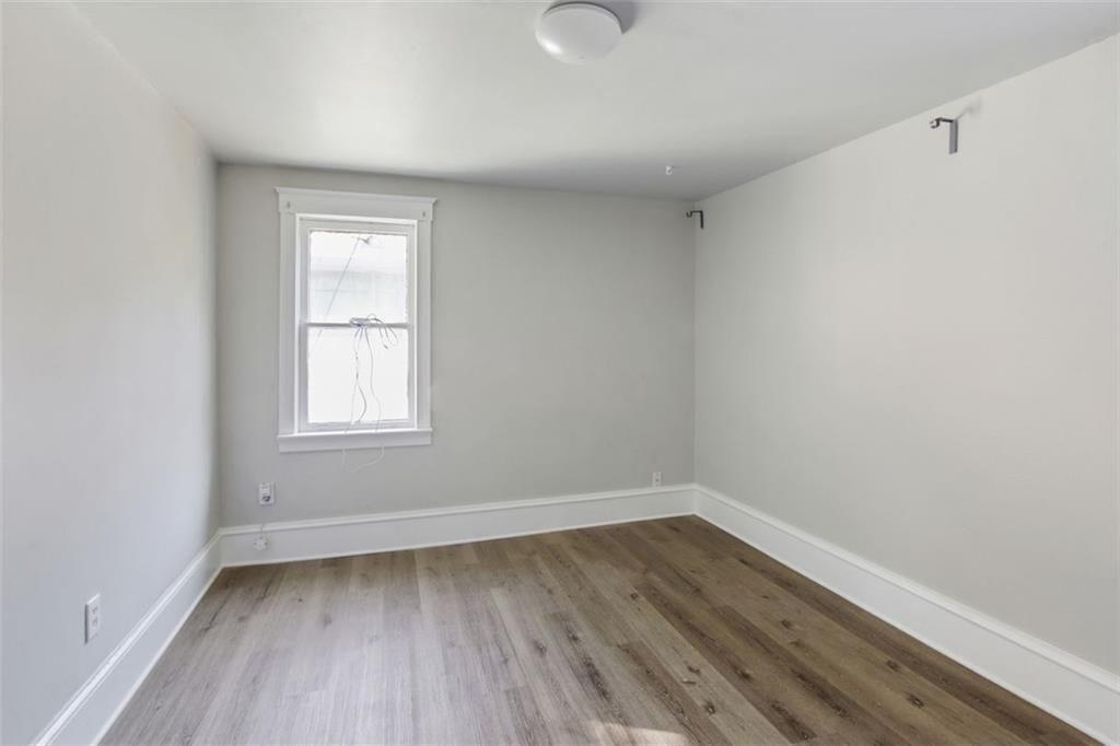 693 Myrtle Street Northeast Atlanta, GA 30308 - Photo 30 of 35 an empty room with wooden floor and windows