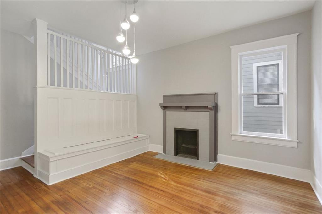 693 Myrtle Street Northeast Atlanta, GA 30308 - Photo 7 of 35 an empty room with wooden floor cabinet and fireplace