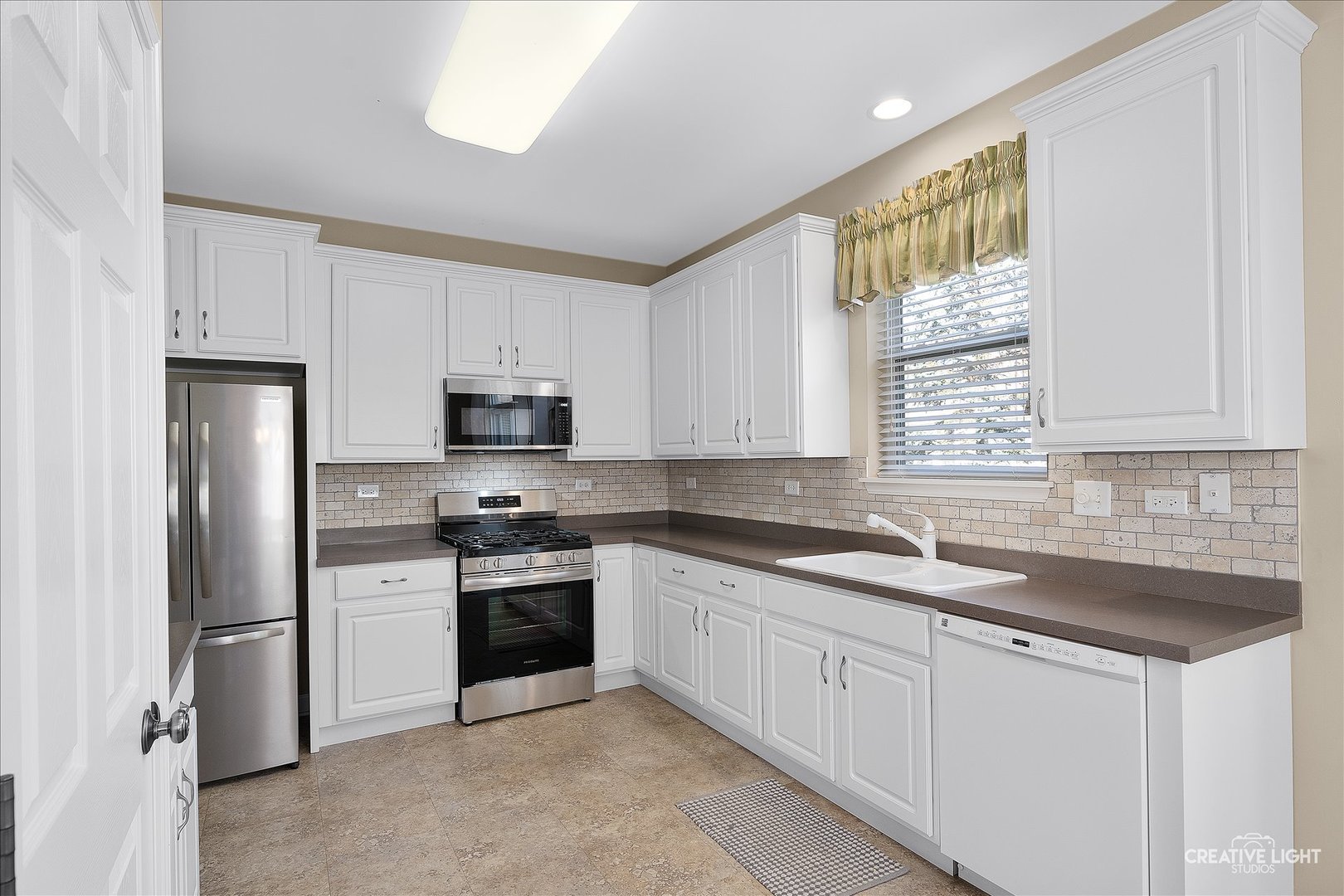 757 Bellevue Circle Oswego, IL 60543 - Photo 9 of 19 a kitchen with granite countertop white cabinets white stainless steel appliances and a sink