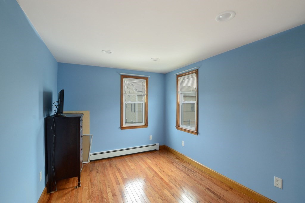 56 Curtis Road Revere, MA 02151 - Photo 14 of 22 a view of an empty room with a window and wooden floor