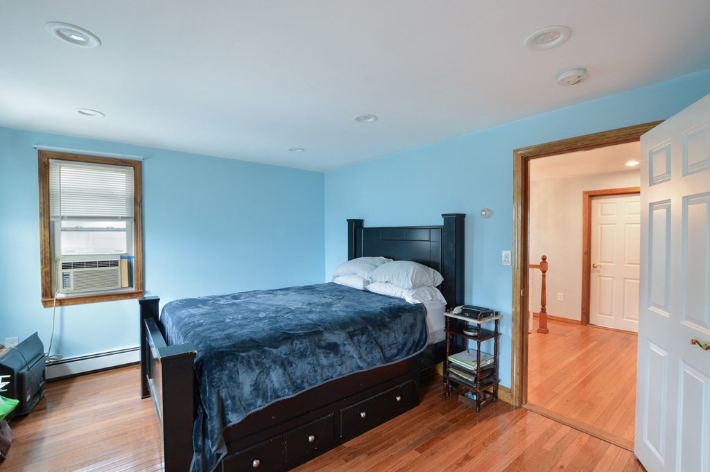 56 Curtis Road Revere, MA 02151 - Photo 19 of 22 a bedroom with a bed and wooden floor