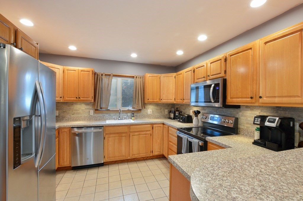 56 Curtis Road Revere, MA 02151 - Photo 4 of 22 a kitchen with stainless steel appliances granite countertop a stove sink microwave and refrigerator
