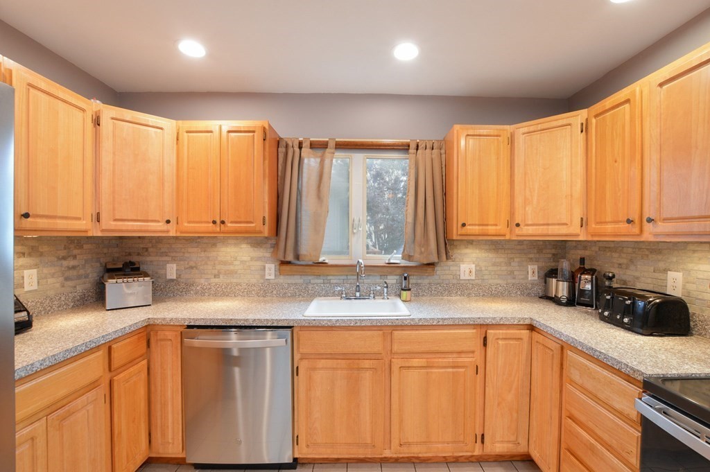 56 Curtis Road Revere, MA 02151 - Photo 5 of 22 a kitchen with stainless steel appliances sink cabinets and window
