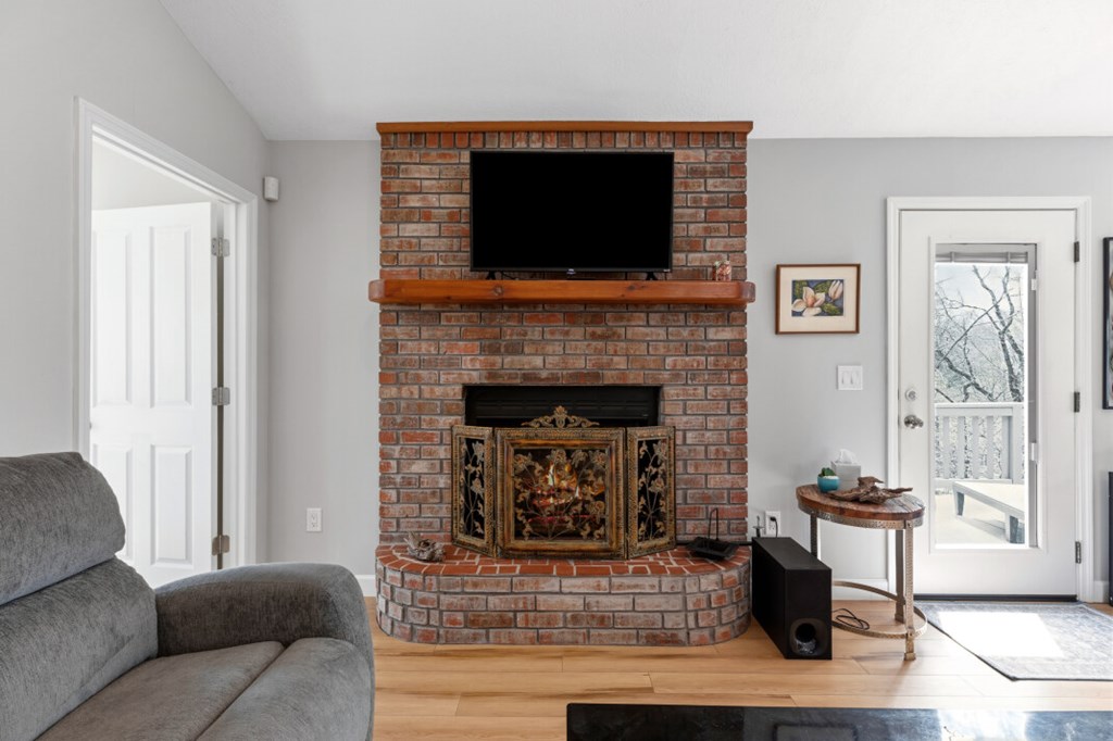 1682 Settlement Road Young Harris, GA 30582 - Photo 17 of 72 a living room with furniture a flat screen tv and a fireplace