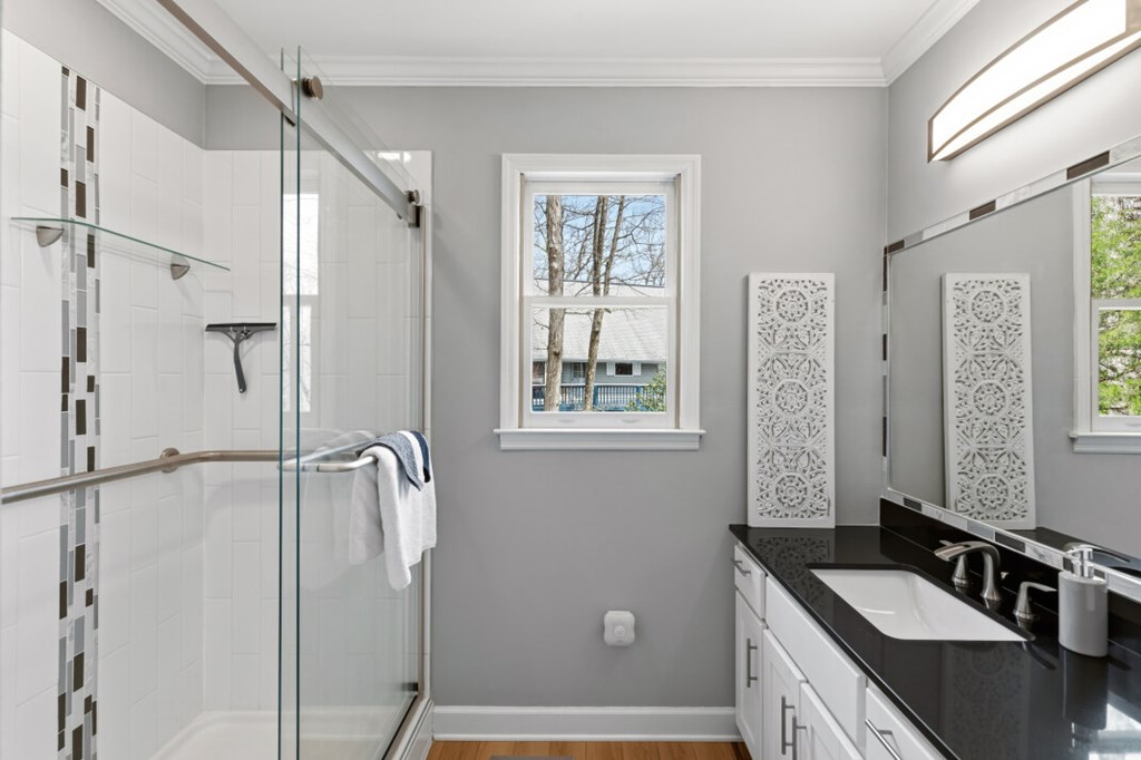 1682 Settlement Road Young Harris, GA 30582 - Photo 28 of 72 a bathroom with a granite countertop sink a mirror a bathtub and shower