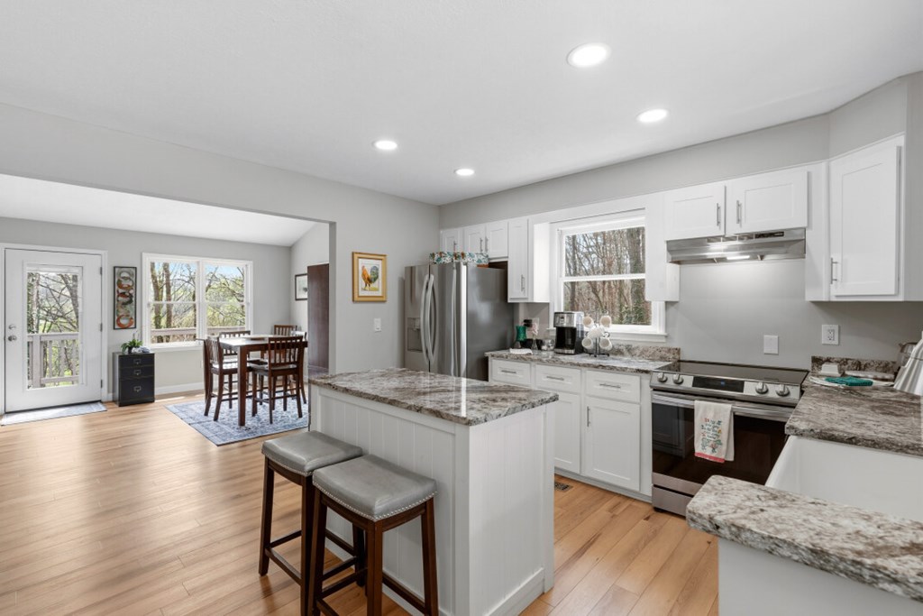 1682 Settlement Road Young Harris, GA 30582 - Photo 8 of 72 a kitchen with kitchen island granite countertop wooden floors and stainless steel appliances