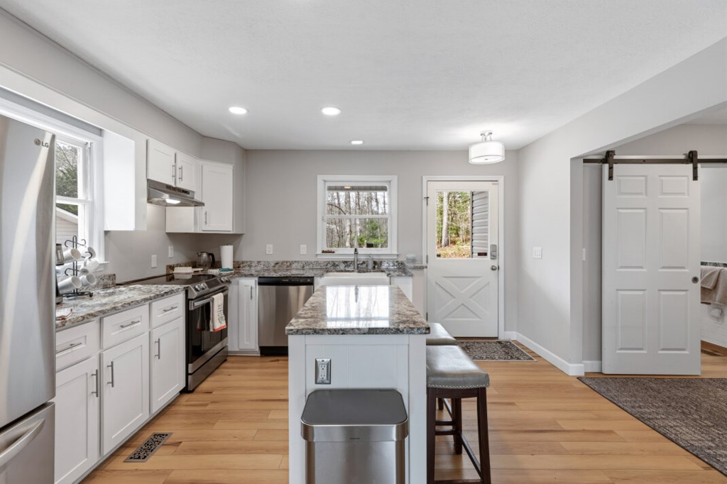 1682 Settlement Road Young Harris, GA 30582 - Photo 10 of 72 a kitchen with stainless steel appliances granite countertop a stove top oven a sink dishwasher a dining table and chairs with wooden floor